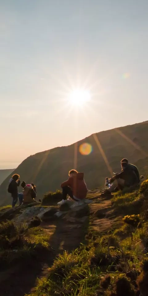 Group of people sitting outside in sunshine.