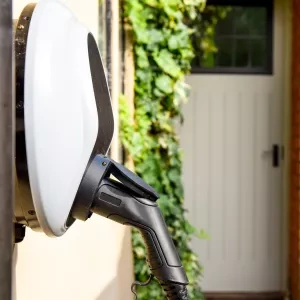 Electric car plugged in to charge outside home with power cable